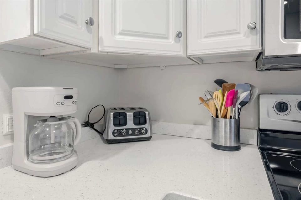 Modern, fully equipped kitchen with stainless appliances and stacked washer/dryer