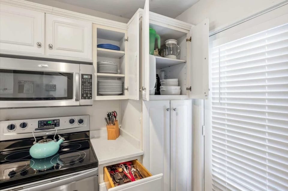 Modern, fully equipped kitchen with stainless appliances and stacked washer/dryer