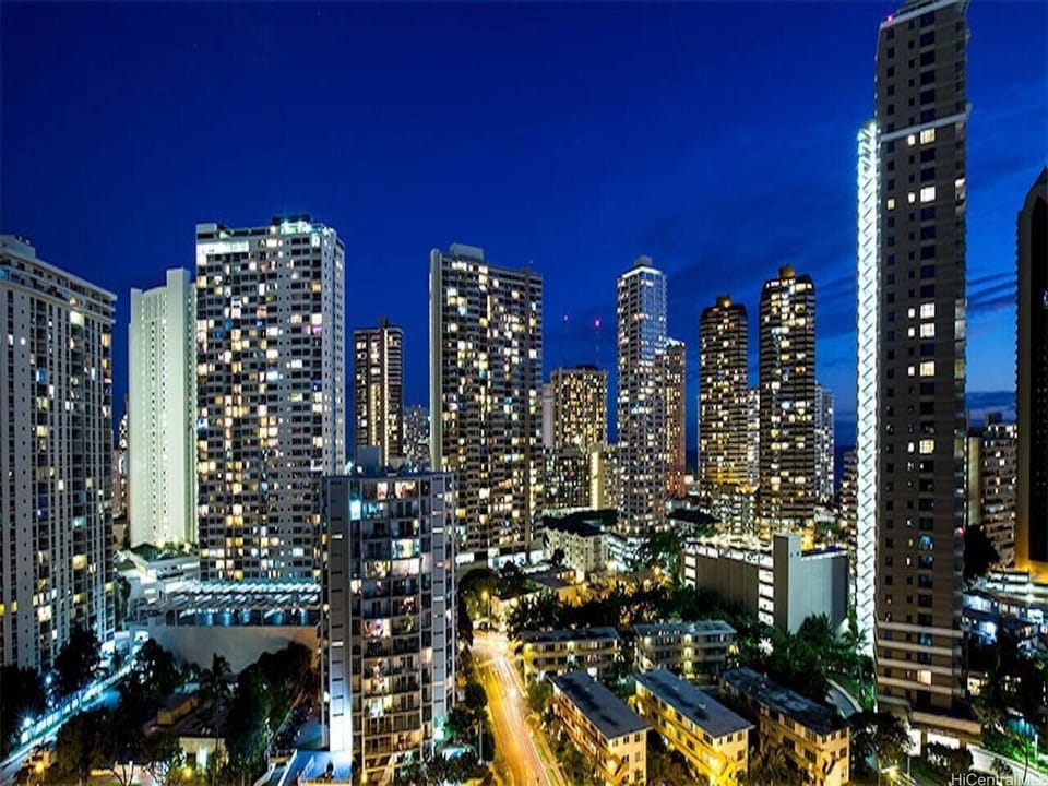 Evenings feel electric with this panoramic view - urban energy meets coastal calm in every window.