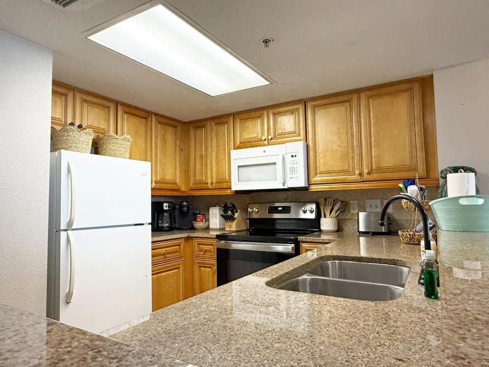 Granite countertops surround the stainless steel stove and double-basin sink in the kitchen.