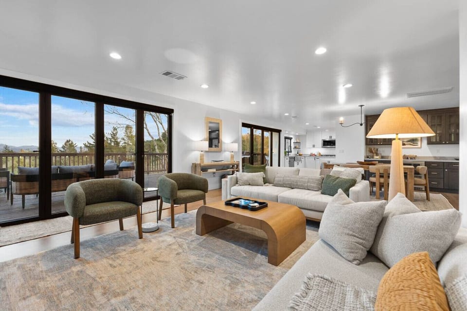 Sunlight pours through floor-to-ceiling glass doors into this designer-styled living space.