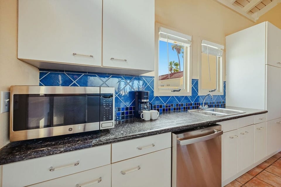Fully equipped kitchen featuring modern appliances, cookware, essentials, and ample space for meal preparation.