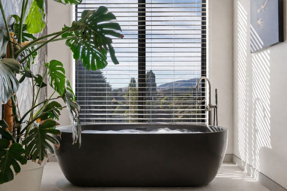 Soak in the sculptural freestanding bath while dappled light filters through the blinds - pure luxury with a side of mountain air