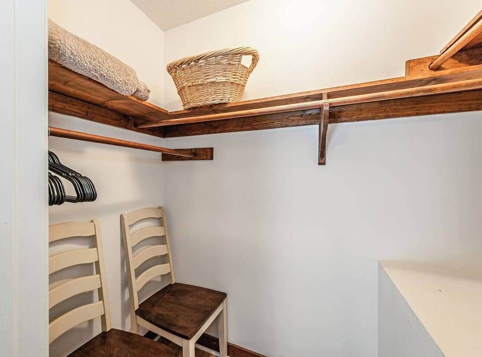 The Bluebell Room offers a queen bed, two dressers including a vanity, and a flat‑screen Amazon TV. Two windows with blackout and noise‑reducing curtains add serenity. Ensuite bathroom and walk‑in closet complete this private, comfortable escape.