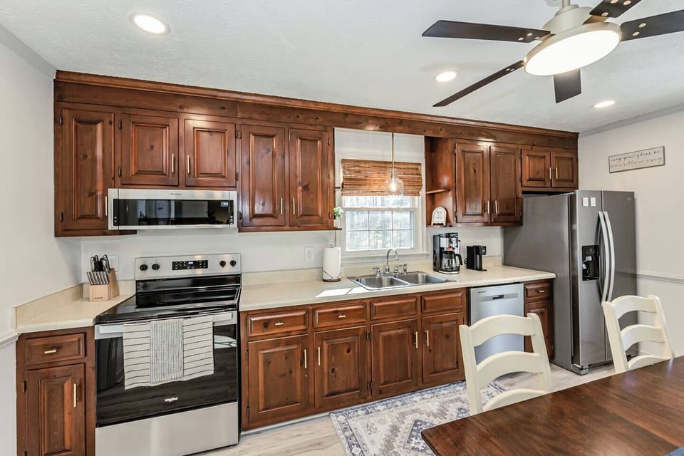 The well‑lit kitchen offers all the essentials, including a microwave, fridge, oven, Keurig and drip coffee, and plenty of cabinet storage. A double‑basin sink sits beneath a sunny window, and the adjacent laundry nook keeps everything convenient.