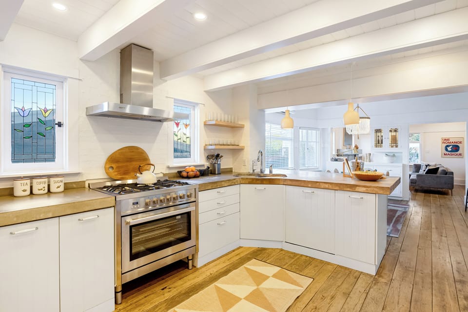 Bright chef’s kitchen with a 6-burner range and breakfast bar seating.