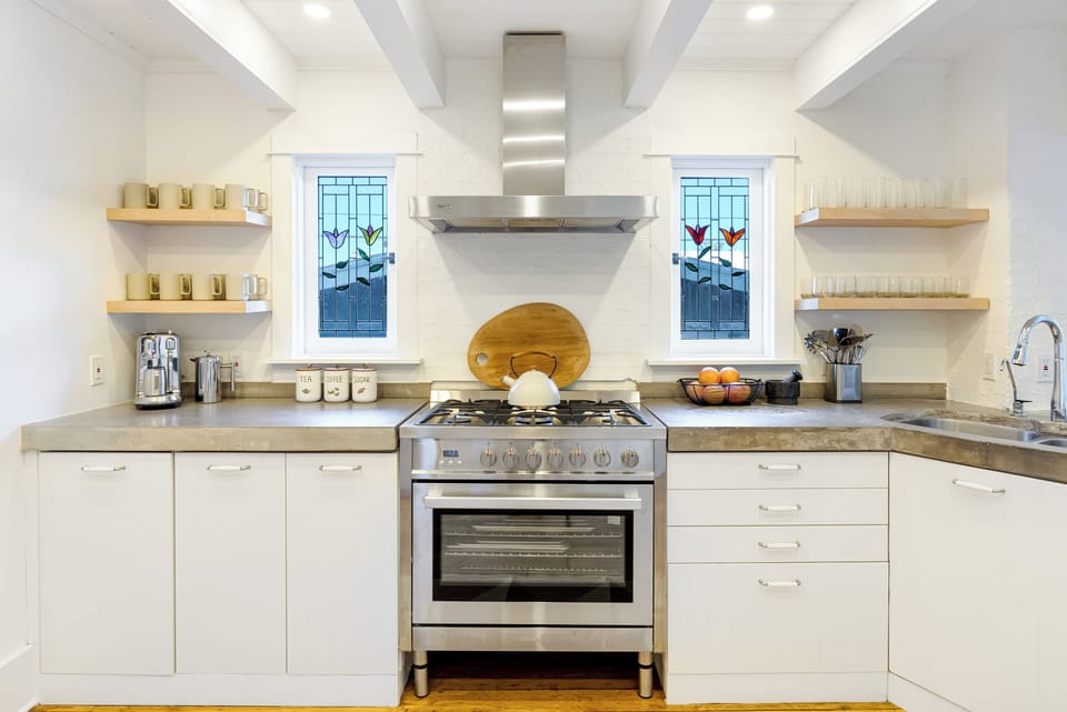 Bright chef’s kitchen with a 6-burner range and breakfast bar seating.