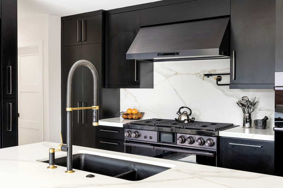Close-up of the professional-grade black range and minimalist range hood.