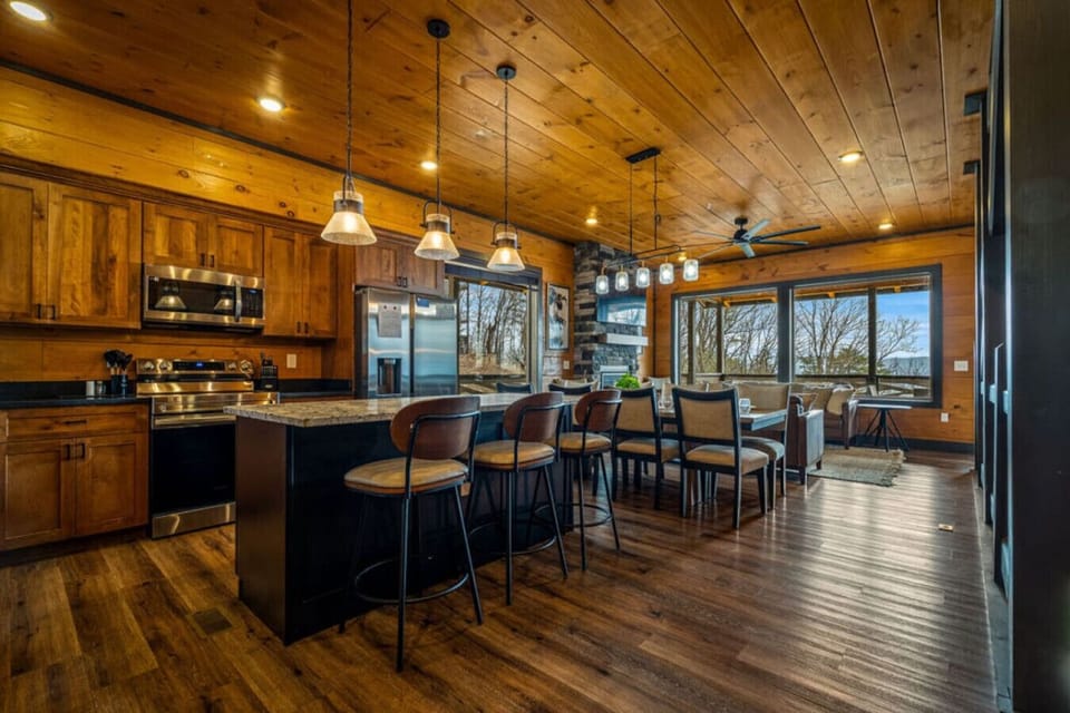 The open kitchen and dining space makes it easy to cook, gather, and share meals together while the warm wood interior surrounds you in classic Smoky Mountain cabin comfort.