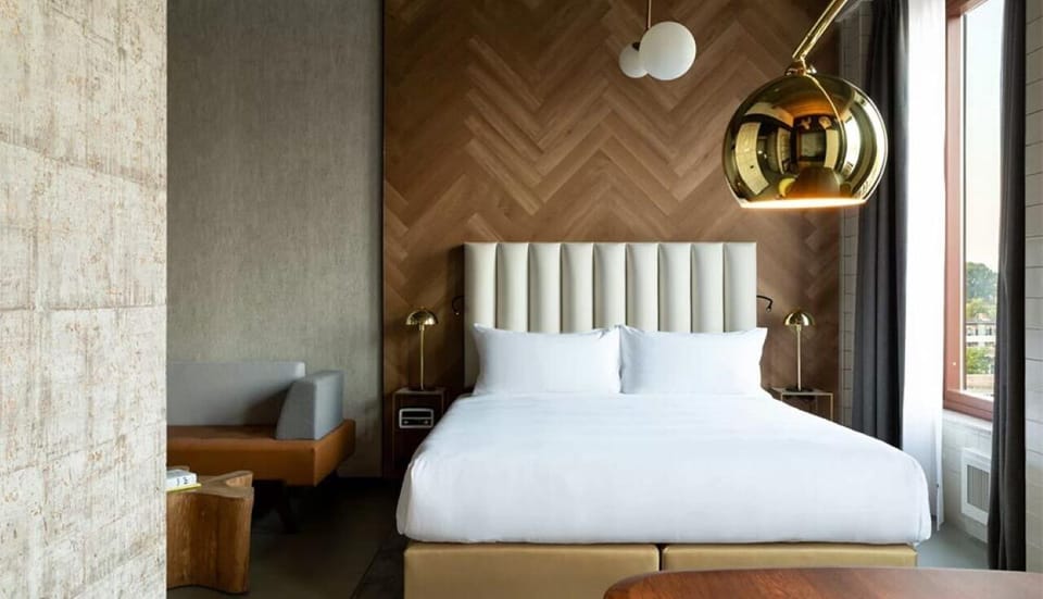 Unwind in a designer king bed under warm pendant light.