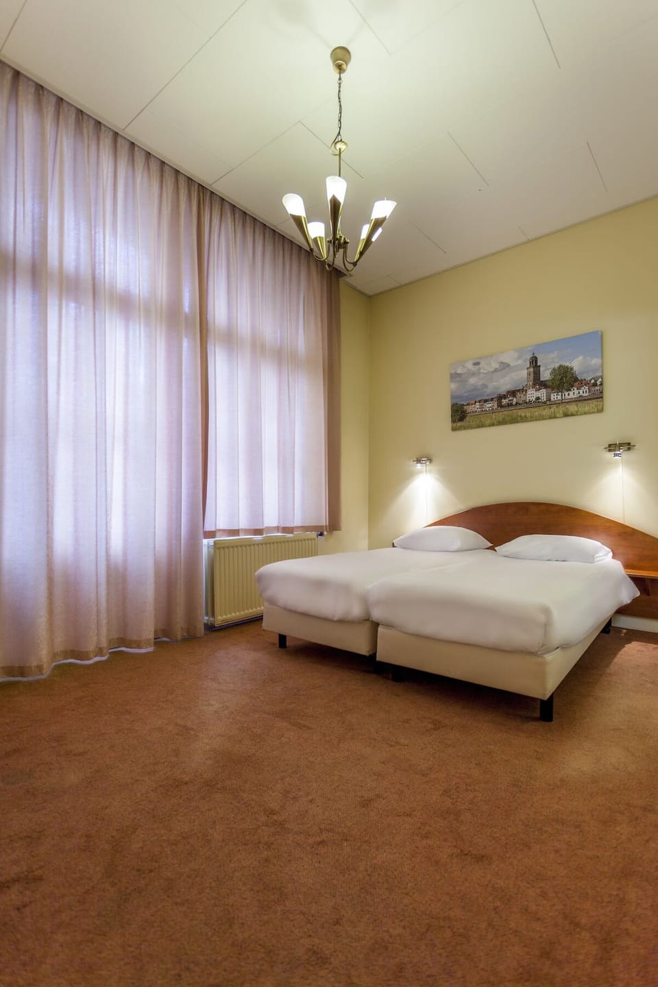 Unwind in a bright bedroom with tall, calming drapes.
