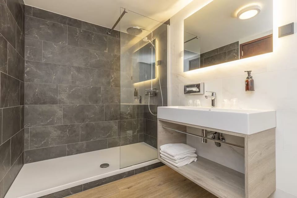 Refresh under a rainfall shower in a sleek modern bath.