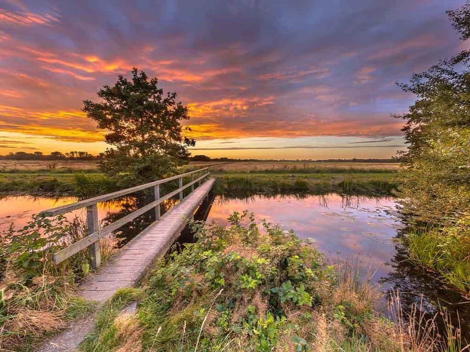 Unwind at sunset beside tranquil waters and open skies