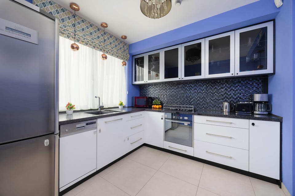 A sleek kitchen with white cabinets and dark countertops. Stainless steel appliances add a modern touch to the space.