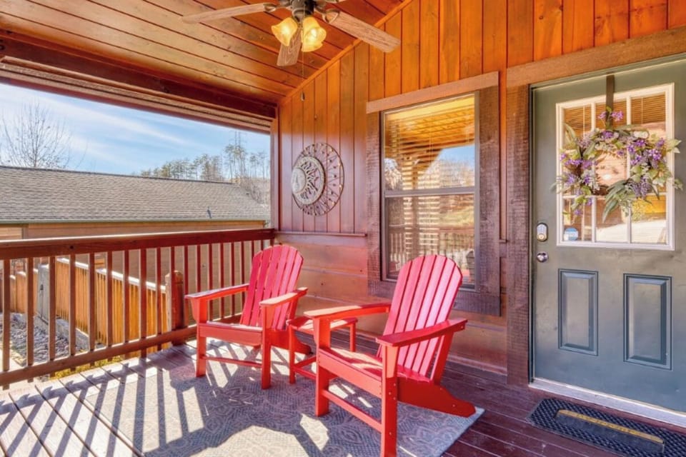 Unwind on your private covered porch with bright red Adirondack chairs, where morning coffee tastes better and mountain views stretch endlessly before you.