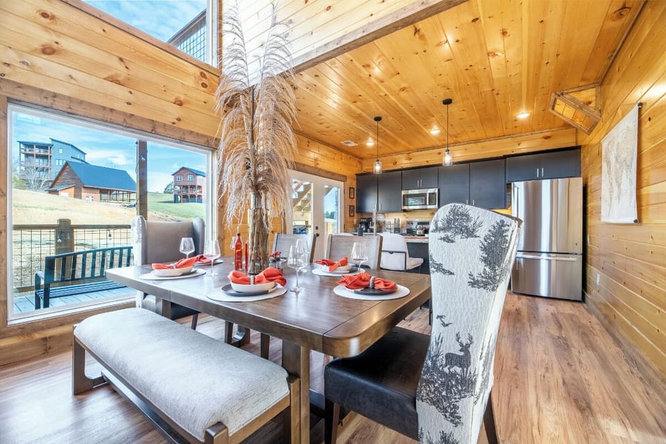 Gather around your warm wood-wrapped dining table where elegant place settings await memorable meals with scenic views beyond.