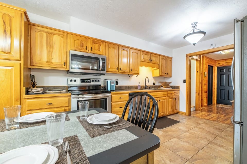 Your fully equipped kitchen awaits with warm wood cabinets, modern appliances, and a welcoming dining space for memorable meals together.