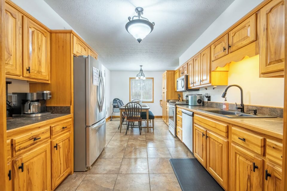 Your spacious galley kitchen features warm wood cabinets, granite countertops, and stainless appliances perfect for preparing memorable meals together.