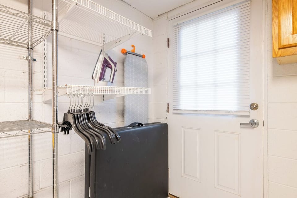 Your dedicated laundry space features a washer, organized shelving, and an ironing board—keeping your vacation wardrobe fresh and wrinkle-free throughout your stay.