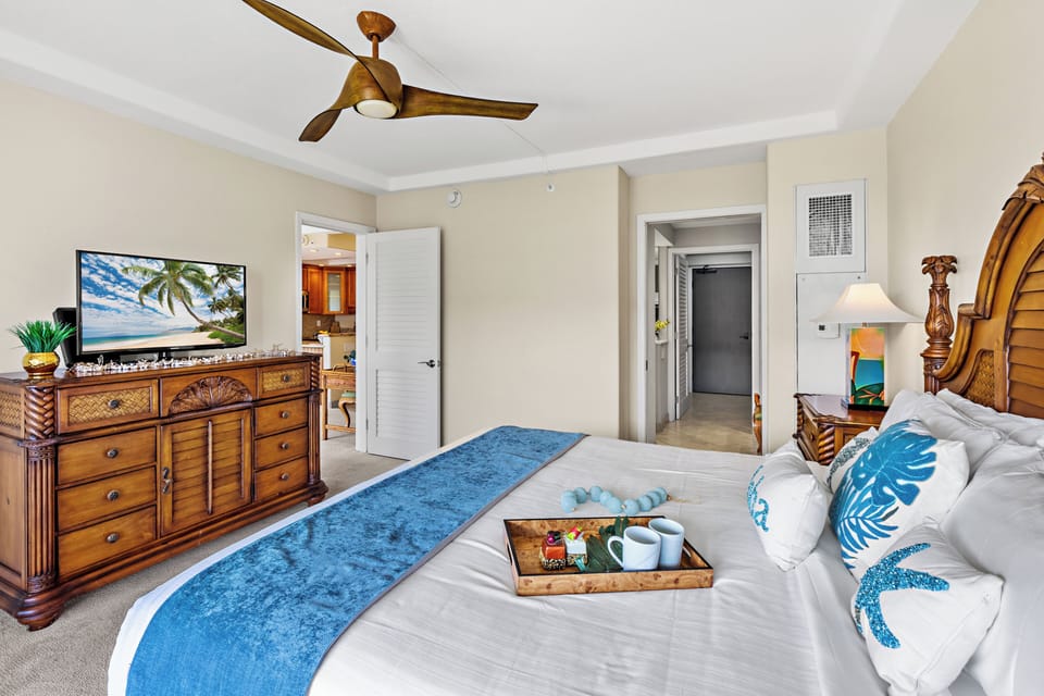 Your tropical-themed bedroom features warm wood furnishings, a ceiling fan for comfort, and thoughtful amenities like room service.