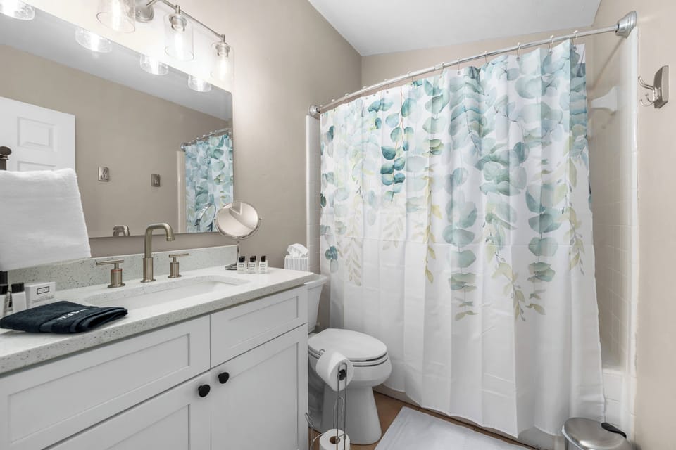 Full bathroom with slow-closing toilet, shower/tub, sink, hotel-quality linens, cosmetic amenities, and under-sink storage (hairdryer included). Beekman shampoo, conditioner, body lotion, and goat milk body bar included.