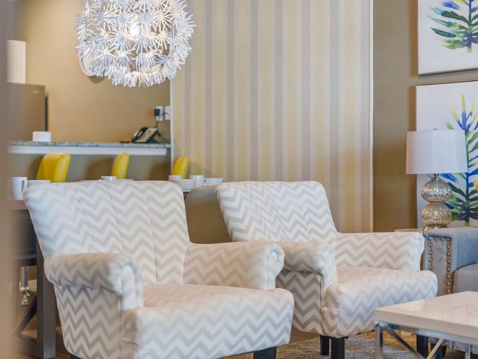 Comfortable seating area with patterned armchairs and modern lighting in a cozy living space.