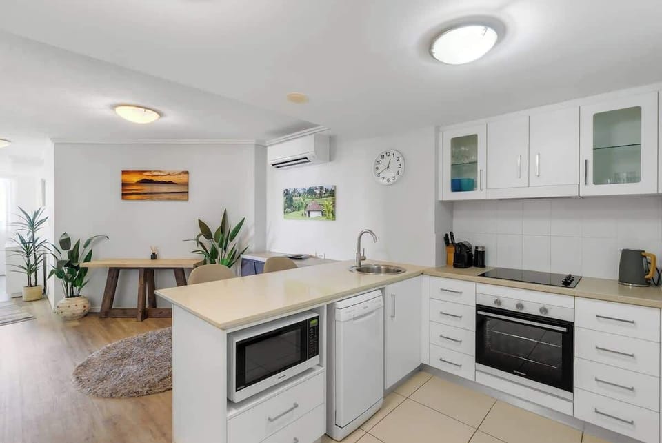The full kitchen features a breakfast bar, dishwasher and all essential appliances — perfect for preparing meals between reef and rainforest adventures.