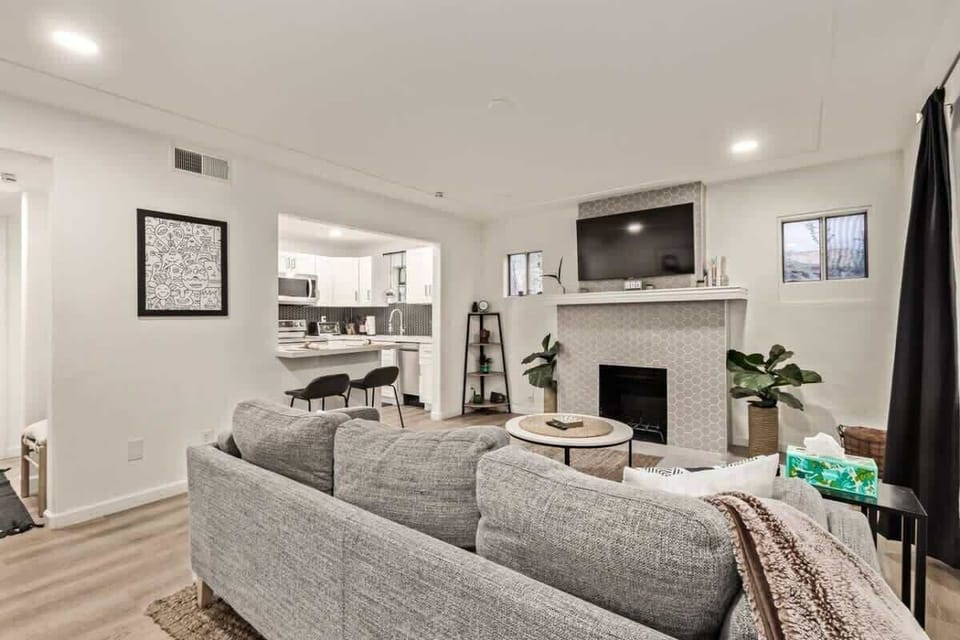Cozy living space with Smart TV, decorative fireplace, and stylish décor, perfect for relaxing after a day in the city.