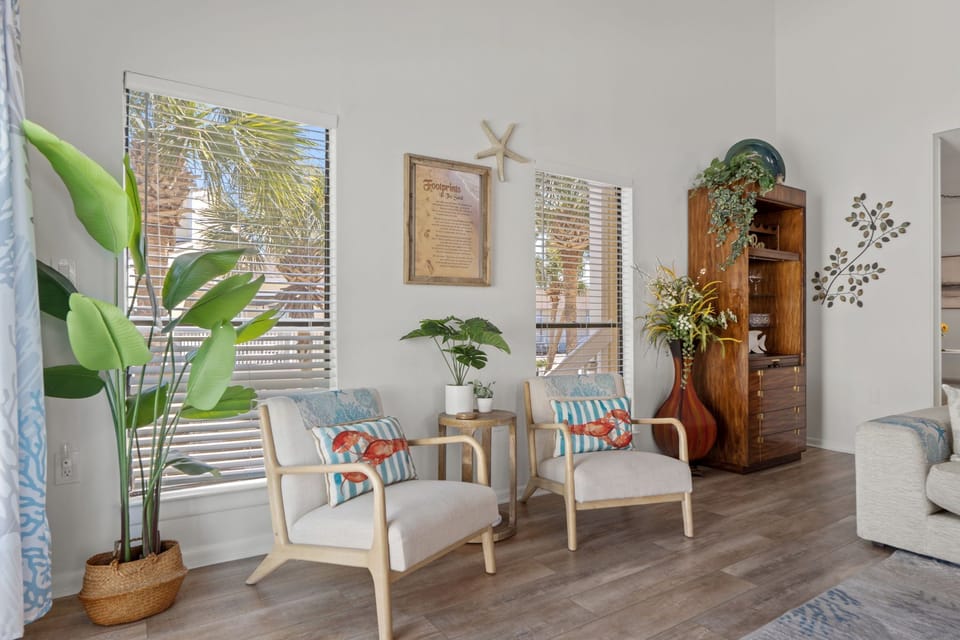 Unwind in your bright tropical retreat with cozy seating, lush plants, and palm tree views.