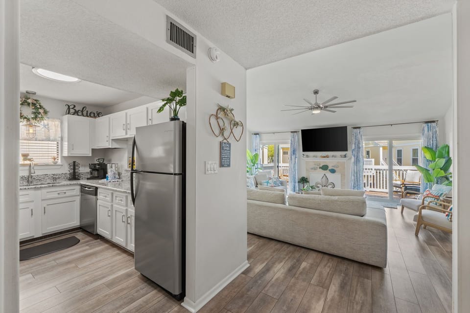Relax in your bright open-plan living space where the kitchen flows seamlessly into the cozy lounge area, perfect for unwinding after beachside adventures.