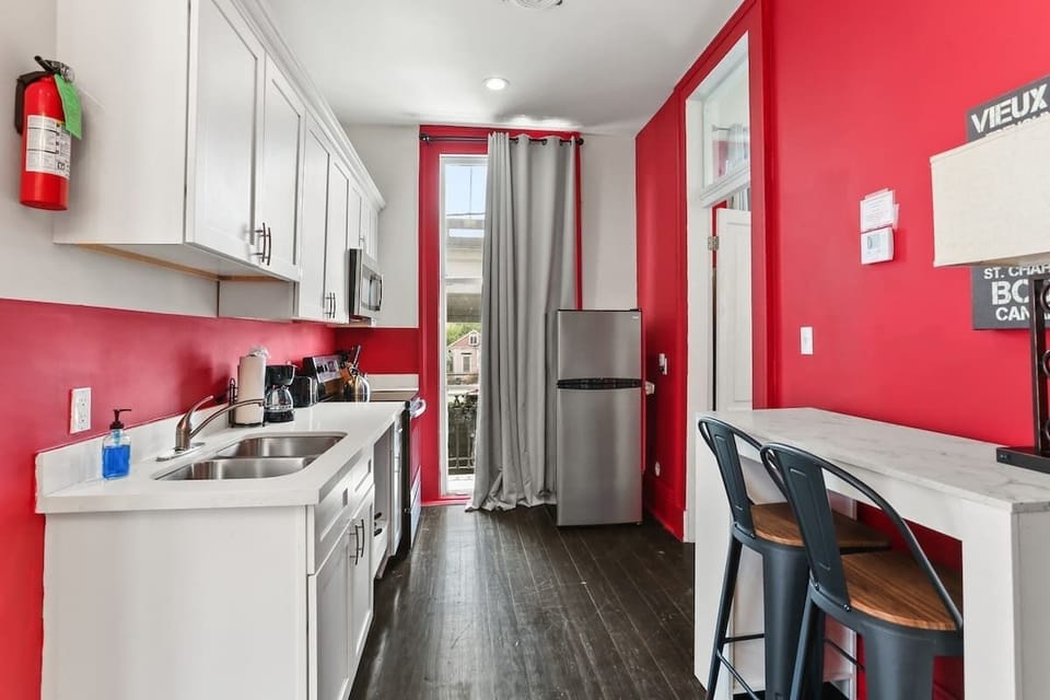 Fully equipped kitchen with modern appliances, ample cabinetry, and a cozy dining nook for two. Bright, functional layout with bold accents, ideal for meals, coffee, or planning your day.