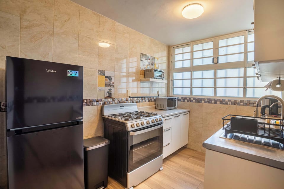 Cook with ease in our full kitchen, featuring a modern refrigerator.