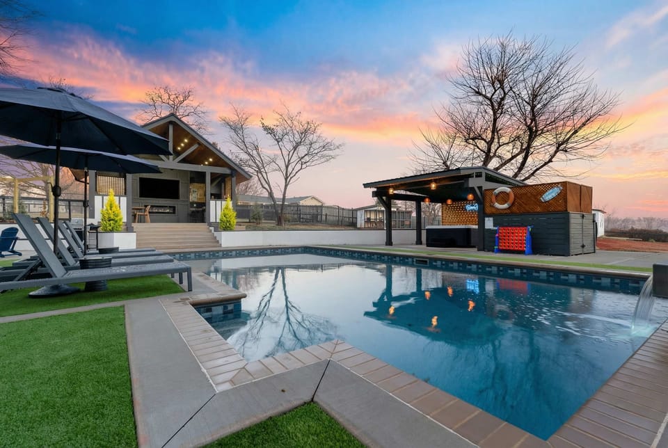 The backyard of Farmhouse Retreat features a heated in-ground pool, hot tub, outdoor entertainment area, and so much more!
