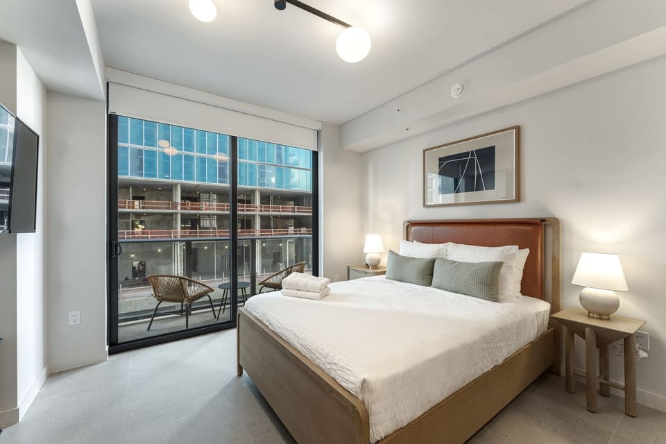 Comfortable bedroom with plush bedding and balcony access.