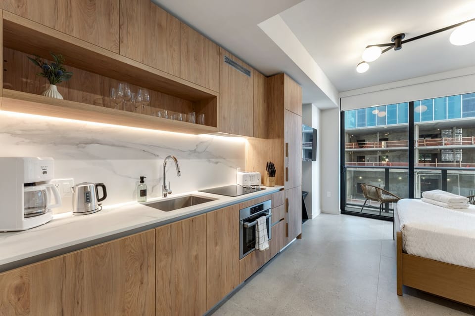 Modern bedroom area with smart TV and city views.