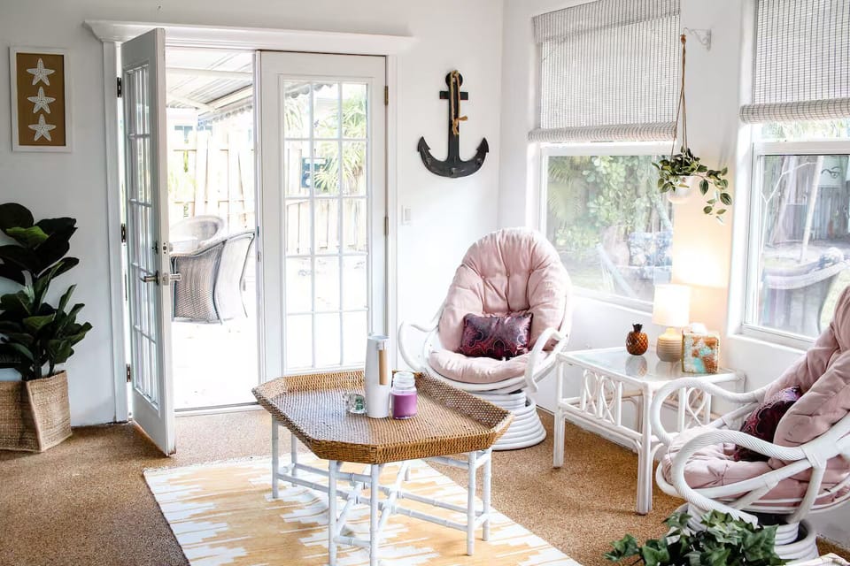 Bright sunroom with cozy seating and patio access.