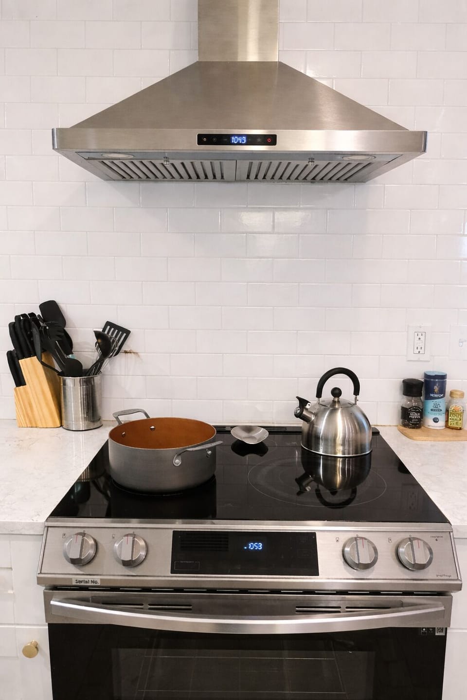 Modern stainless steel stove with sleek range hood and quartz countertops.