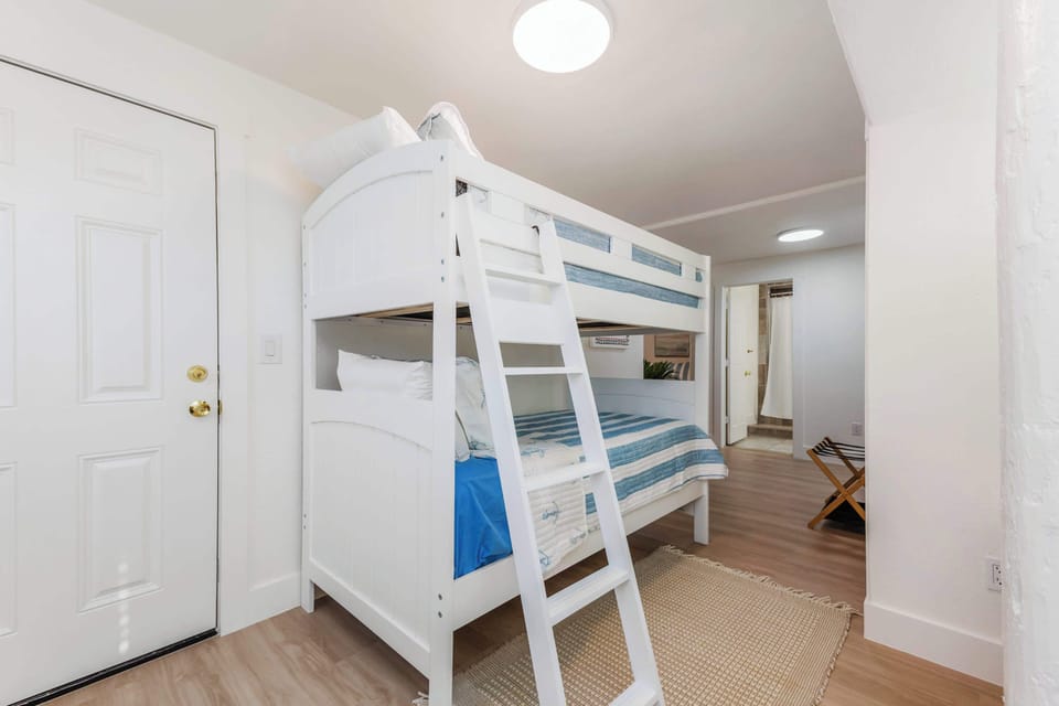 Spacious bedroom 3 with twin/twin bun bed, 2 queen beds, Smart TV, and exterior door 