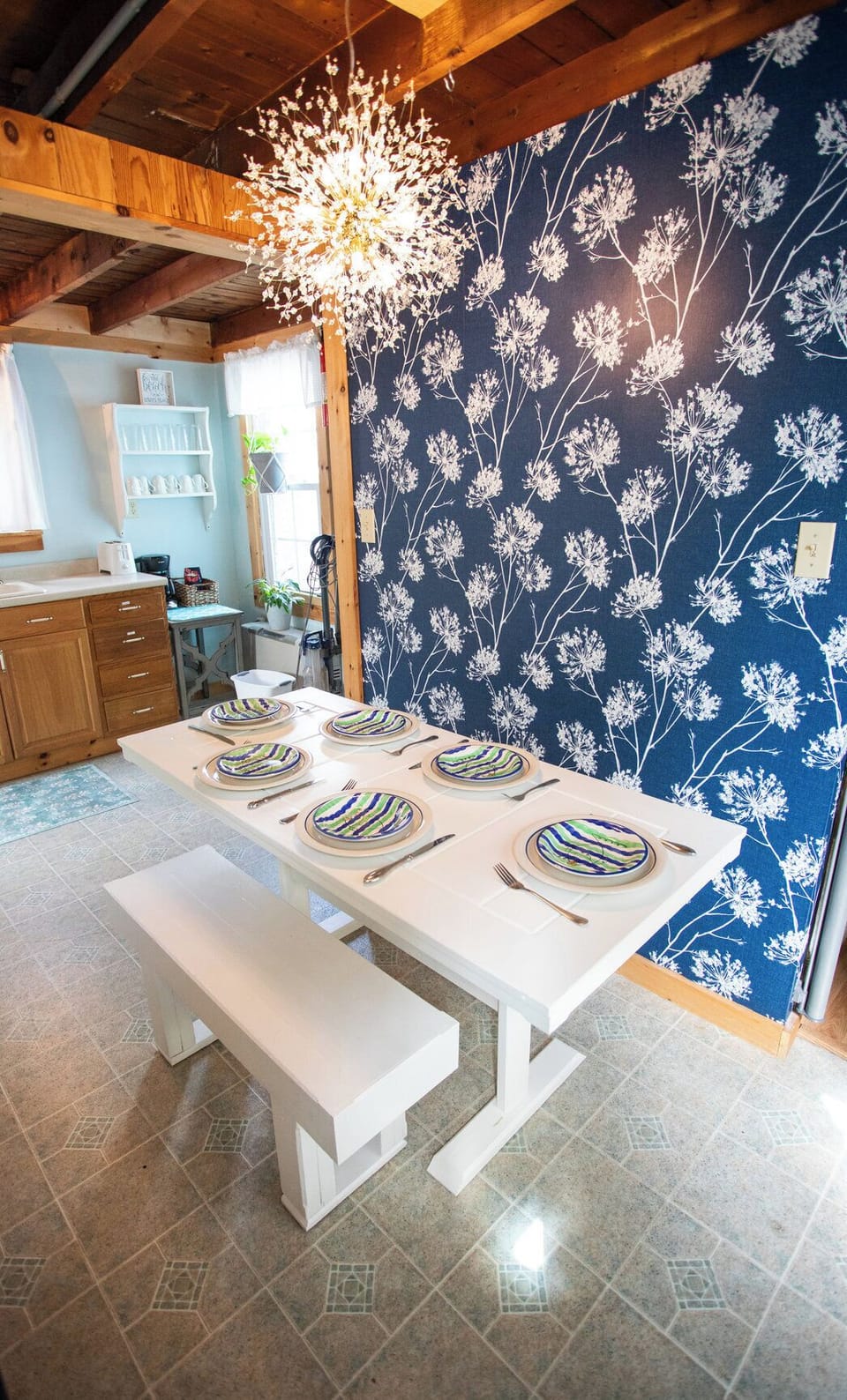 Dinner for six under the starburst light — coastal plates, cottage beams, and easy vacation meals.