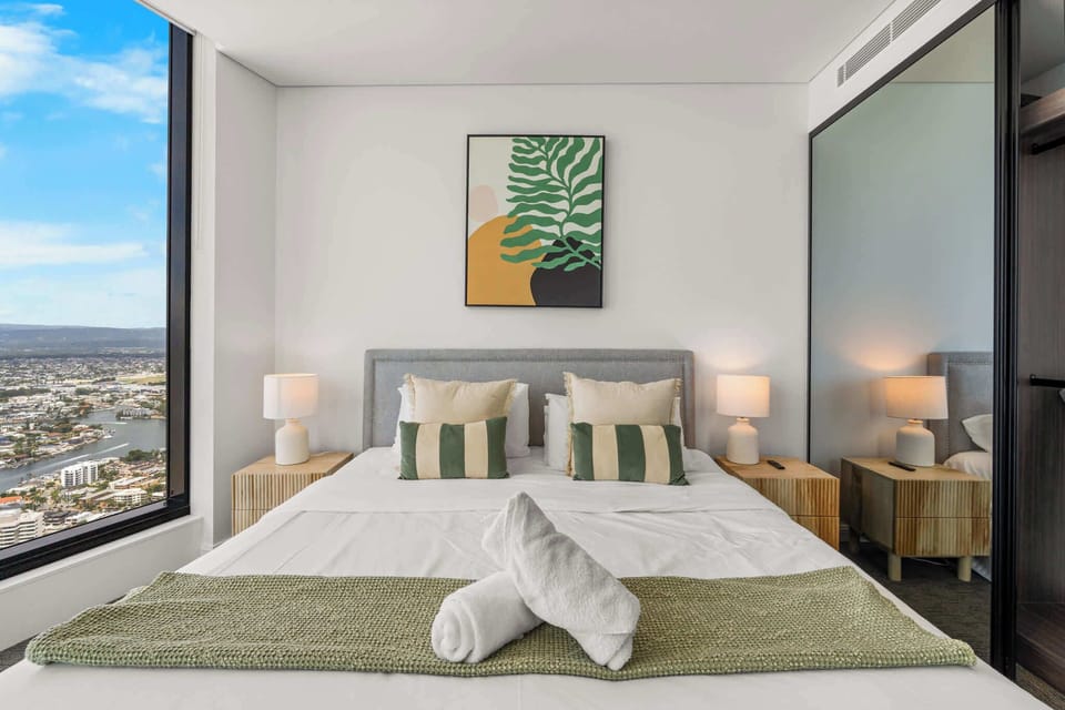 Luxury master retreat at Meriton Ocean offering balcony access, king-size bedding, and sweeping east-facing ocean and Gold Coast skyline vistas.