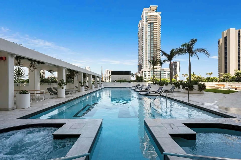 Resort-style outdoor pool on Level 5 with sun lounges and landscaped surrounds, perfect for a relaxed daytime swim. (subject to availability)
