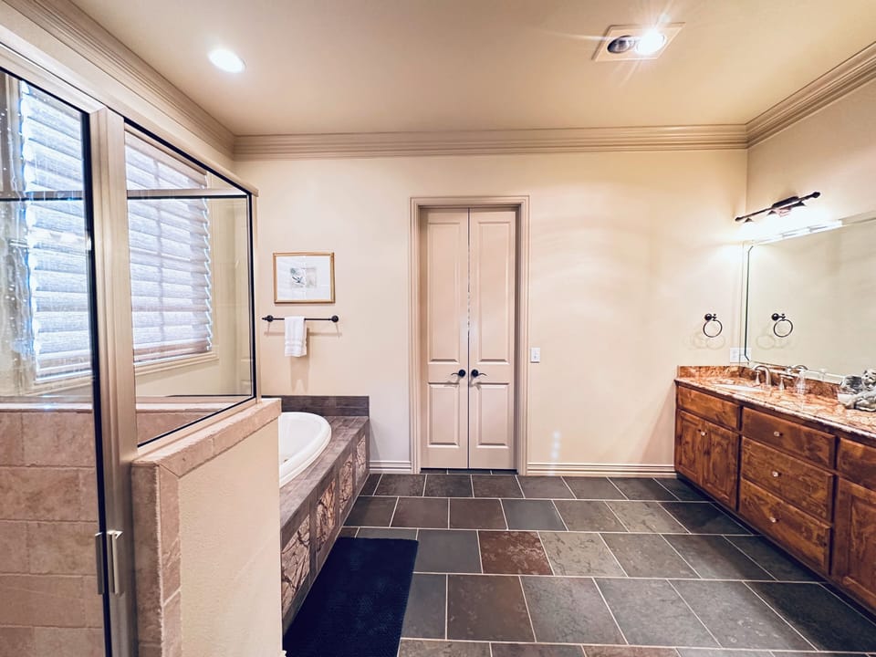 Spacious master bedroom with separate shower and soaking bathtub.