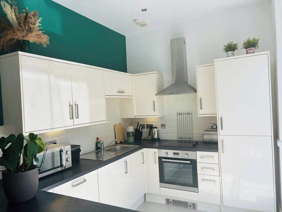 Whip up your favorite meals in this well-equipped kitchen, featuring a convenient sink, microwave, oven, and ample kitchen cabinets for all your culinary needs.