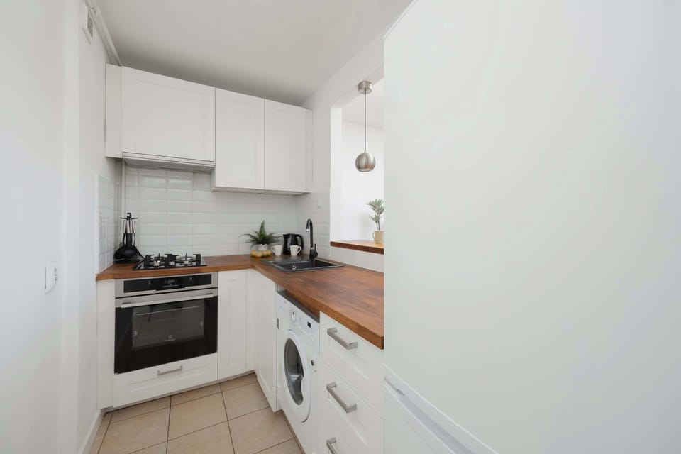 Fully equipped kitchen with oven, stove and wooden countertops.