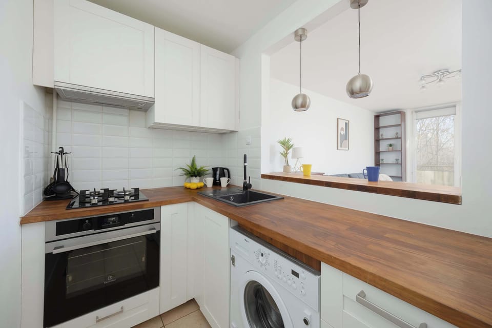 Fully equipped kitchen with oven, stove and wooden countertops.
