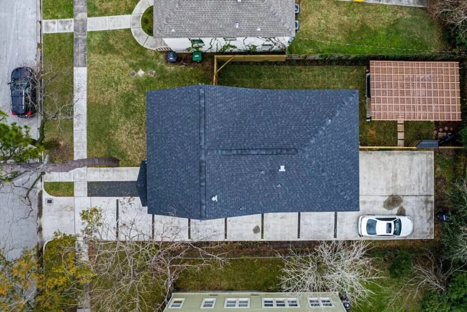 An overhead view of the full property — private outdoor space, hot tub, pergola, and dedicated parking for up to 7 cars.