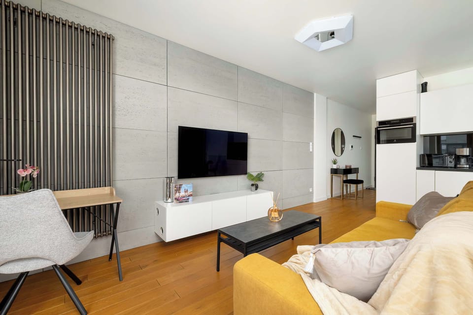 The living area features a sleek coffee table and a flat-screen television.