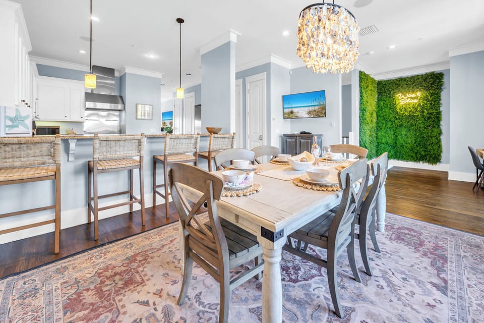 Gather around your stylish dining table beneath the sparkling chandelier, where every meal becomes a celebration in this elegant open space.