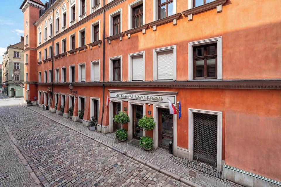 A charming cobblestone street located near the studio building. Historic orange-toned facades create a warm and picturesque neighborhood setting.