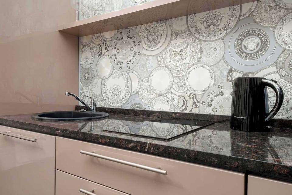 A close-up of the studio’s modern kitchenette with a stove and kettle. The patterned backsplash adds personality to the compact cooking space.